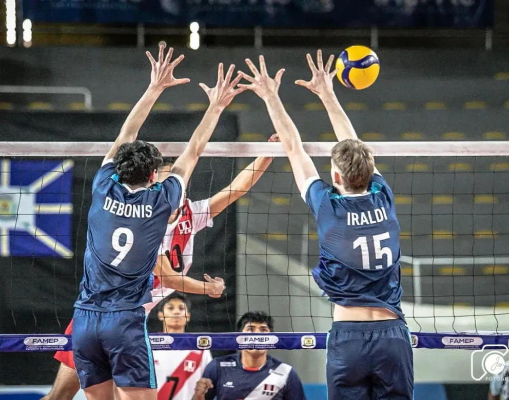 Juan Cruz Iraldi (15) dando pelea en el bloqueo ante Perú. El jugador local y Argentina clasificaron al Mundial.