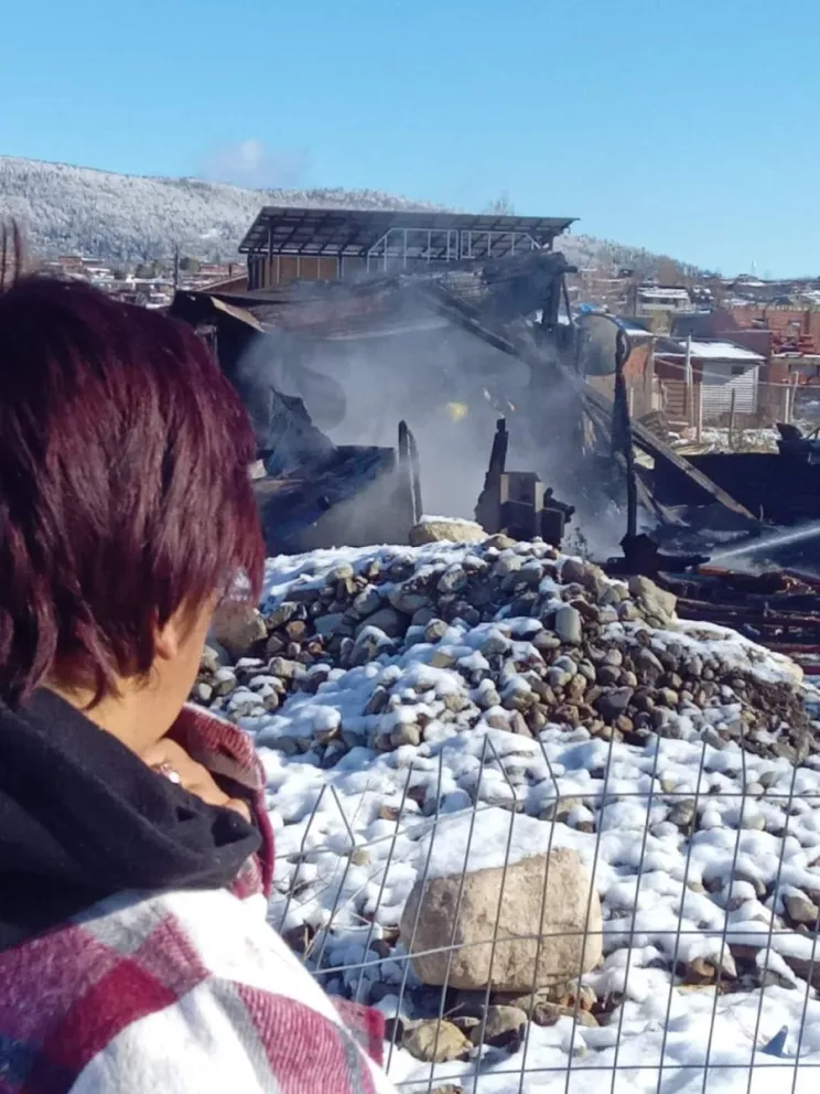 La mujer mira los restos de su vivienda que fue consumida por el fuego. Foto: gentileza