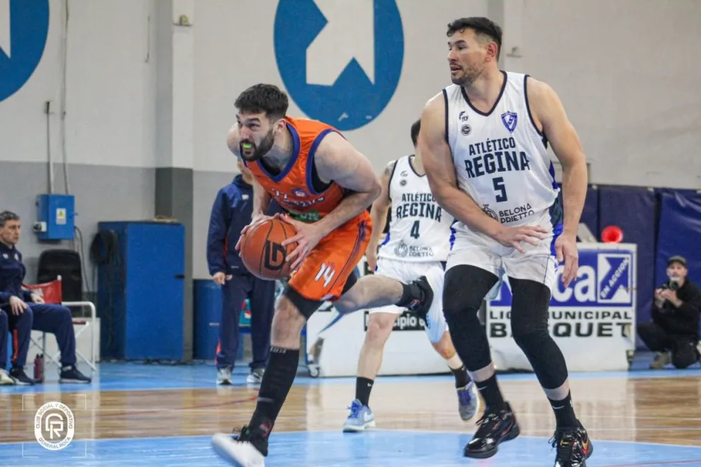 Benjamín López (Roca) intenta buscar el aro ante la marca de Martín Chervo (Regina). Foto: prensa Deportivo Roca.