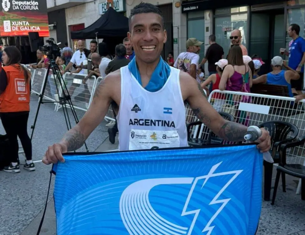 Ricardo, en la meta en España y con la bandera de la Escuela Correcaminos. Foto: gentileza